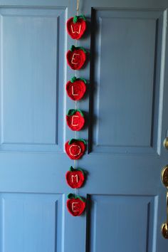 the door is decorated with red felt apples