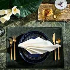 a place setting with napkins, silverware and flowers