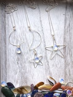 "These unique hand shaped moon and star necklaces are a totally original design and a one-of-a-kind must-have for the celestial lover. A glowing teardrop opalite accents each pendant. Each handmade pendant comes on a 28\" sterling silver ball chain. I carefully shape each pendant by hand from tarnish-resistant silver wire. These are super lightweight and hang beautifully. Please select the necklace you would like from the drop down menu. Pendant lengths: Star measures 2.5\" Moon measures 2.75\" Adjustable Celestial Star Jewelry, Celestial Star-shaped Sterling Silver Jewelry, Mystical Teardrop Jewelry For Jewelry Making, Mystical Teardrop Nickel-free Jewelry, Adjustable Star-shaped Magical Jewelry, Mystical Nickel-free Teardrop Jewelry, Moon Shaped Jewelry With Star Charm For Gifts, Moon Phase Star Shaped Jewelry Gift, Mystical Silver Star Jewelry