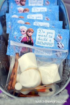 some marshmallows and cinnamon sticks in a plastic bag with frozen princess stickers on them