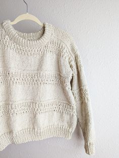 a white sweater hanging on a hanger