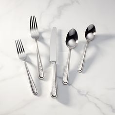 four forks, two spoons and one knife on a marble surface