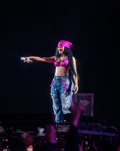 a woman in pink top and jeans on stage