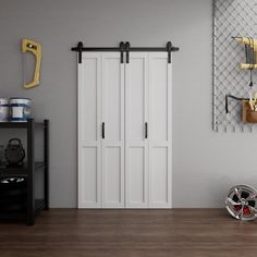 a room with two white doors and some yellow hooks on the wall next to it