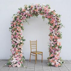 a chair sitting in front of a floral arch