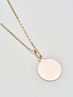 Sentimental? Same. The Disk Pendant handcrafted in L.A. from 14Kt gold is the perfect piece to engrave with a memorable message. Make it even more personal by stringing it from a chain of your choice. 14Kt Yellow Gold Disk Pendant Width: 20mm Sold solo with a silk cord Pictured with Petite Industrial Box Link Chain Shop all chain options Made in L.A. Engraved Medallion Necklace For Everyday Wear, Everyday Engraved Medallion Necklace, 14k Gold Pendant Medallion Necklace, Minimalist Recycled Gold Medallion Jewelry, Yellow Gold Oval Pendant Medallion Necklace, Tarnish Resistant, Everyday White Gold Coin Pendant Jewelry, Engraved Gold Plated Medallion Necklace, Minimalist Yellow Gold Medallion Pendant Necklace, 14k Gold Filled Yellow Gold Coin Pendant Jewelry