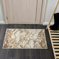 a white and brown rug sitting on top of a wooden floor next to a door