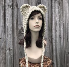 a mannequin head wearing a crocheted bear hat on top of a table