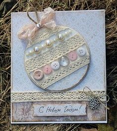 a close up of a card on the ground with buttons and laces in it