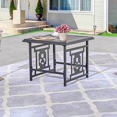 a small table with a potted plant on it in the middle of a patio