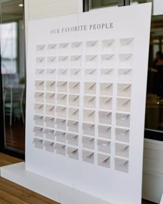 a large white calendar sitting on top of a wooden table next to a glass window