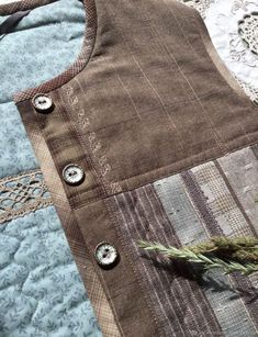 a close up of a piece of cloth with buttons on it and a plant in the middle