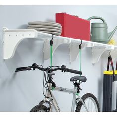 two bikes are parked next to each other in front of a wall mounted shelf with hooks