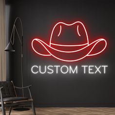 a neon sign that says custom text with a cowboy hat on the wall behind it