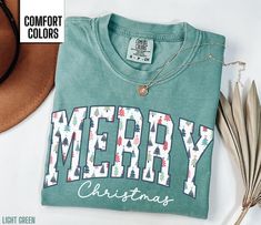 You will love this Merry Christmas shirt for women.  It says Merry in a beautiful Christmas tree font along with Christmas in a script font. This will be the perfect shirt for any woman to wear this holiday season.  Share your Christmas cheer with others this winter. Find our long sleeve tee and crewneck sweatshirts here: Short Sleeve Tee: https://etsy.me/4dGGUaR Long Sleeve Tee: https://etsy.me/3U0W2sW Crewneck Sweatshirt: https://etsy.me/4dxXqKl Comfort Colors T shirt Details: 100% ring-spun c Christmas Shirt For Women, Christmas Green T-shirt With Letter Print, Green Christmas T-shirt With Letter Print, Holiday Green T-shirt With Letter Print, Winter T Shirt, Christmas Shirts For Women, Winter T Shirts, Diy Shirts, Cute Christmas Shirts