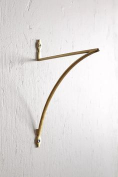 a white wall with a pair of wooden hooks attached to it's side,