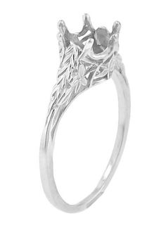 a white gold ring with an intricate design on the front and side, set in 18k white gold