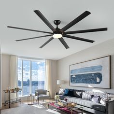 a living room filled with furniture and a ceiling fan in front of a large window