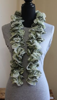 a mannequin wearing a gray shirt and green ruffled scarf on it's neck