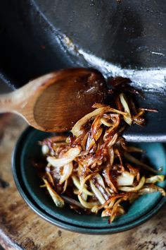 a wooden spoon scooping food out of a bowl