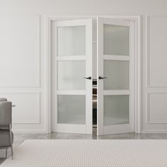 an empty room with white walls and two chairs in front of the glass doors that are open