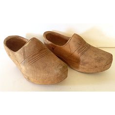 an old pair of wooden clogs on a white surface