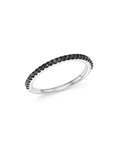 a white gold ring with black diamonds on the sides and a thin band in the middle