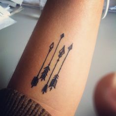 an arrow tattoo on the wrist with arrows and stars in it's middle arm