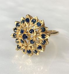 "Sapphire Ring, Blue Sapphire Ring, Sapphire Ring for Women, Sapphire Sunburst Ring, Vintage Sapphire Jewelry, Vintage Gold Ring, OOAK Ring A beautiful and intricately detailed never before owned vintage 14k yellow gold \" Sunburst\" ring featuring approximately 0.80 carats of round sapphires set within marquise shaped \"rays\". *Approximate ring weight: 6.19 grams * Ring size: 6 3/4 * Complimentary resizing is available up to 3 sizes larger or smaller than stated size." Fine Multi-stone Sapphire Ring, Sapphire Cluster Ring With 17 Jewels, Yellow Gold Multi-stone Cluster Sapphire Ring, Yellow Gold Cluster Multi-stone Sapphire Ring, Heirloom Sapphire Multi-stone Ring, Yellow Gold Sapphire Rings With Multi-stone, Fine Jewelry Sapphire Ring With 17 Jewels, Multi-stone Sapphire Round Ring, Cluster Yellow Gold Sapphire Ring