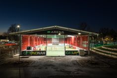 an empty tennis court lit up at night