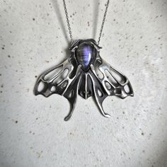 The Aurora moth pendant, ready to ship. Sterling silver, oxidized for depth and contrast; handmade. Features a labradorite cabochon with a dark gray body and purple flash. The Moth  image perfectly reflects one of the core concepts which drives my work--rebirth, transformation, continuity, and the cyclical nature of life. It's a symbol of ongoing development. I sought to capture my admiration for the intricate and ornamental beauty of nature. . Please note! Chain is not included. ✈️ Shipping from Thailand. Please kindly allow 2-4 weeks to arrive. ... About 5 cm/1,97 inch long Only 1 available Witch Amulet, Moth Pendant, Purple Flash, Silver Jewelry Necklace, Labradorite Cabochon, Purple Labradorite, Baby Bag, Jewelry Necklace, Sterling Silber