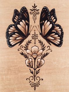 two butterflies are sitting on top of a piece of wood that is decorated with flowers and leaves