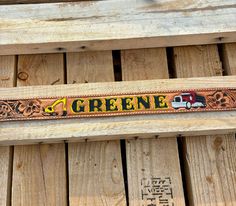 a close up of a wooden bench with a sign on it that says greenie