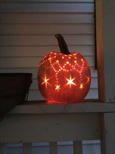 a lighted pumpkin sitting on top of a porch