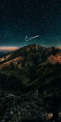 an airplane is flying in the night sky over some mountains and hills with stars above