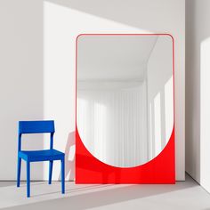 a blue chair sitting next to a red and white mirror