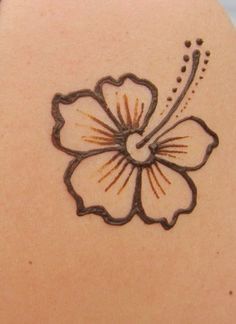 the back of a woman's shoulder with a flower tattoo on it