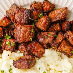 a white plate topped with meat and rice