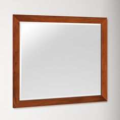 a wooden framed mirror hanging on the wall