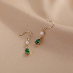 Introducing our stunning minimalist teardrop emerald gold and pearl drop earrings! Handcrafted with care and attention to detail, these earrings are the perfect blend of classic and modern style. The teardrop-shaped emerald gemstones are delicately set in 18k gold plated, giving these earrings an elegant and timeless look. The addition of the lustrous cultured pearls adds a touch of sophistication to these already stunning earrings. Measuring approximately 31mm in length, 5mm width, these earrin Gold Pearl Drop Earrings For May Birthstone, Elegant Teardrop Earrings For May Birthstone Gift, Classic Green Pearl Drop Earrings, Green Elegant Pearl Drop Earrings, Elegant Green Teardrop Pendant Earrings, Elegant Green Drop Pearl Earrings, Elegant Green Pearl Drop Earrings, Elegant Dangle Pearl Earrings For May Birthstone, Elegant Teardrop Earrings For May Birthstone