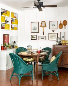 a dining room table with chairs and pictures on the wall above it, along with other furniture