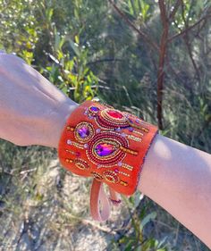 This orange velvet cuff is perfect for those who wants to add a bit of personality to their look. If you look for something unique, this eye catching one of kind jewelry is exactly for you!  Handmade unique design cuff is embellished with crystals shaped into geometric ornaments.  Bracelet is finished with a soft material - ultrasuede that is pleasant and comfortable to wear. Bracelet is adjustable, it is fastened with velvet ribbon. Main color is orange with fucsia, gold, blue, orange, purple, green accents. The actual colors may differ slightly from the one you see on your monitor screen, as it depends on the specific monitor settings. 🎁Jewelry comes in a beautiful box and is ready for gift giving. READY TO SHIP!   💎Materials:  velvet, crystals, glass beads Back side - ultrasuede. 💎Di Handmade Orange Cuff Bracelet Gift, Handmade Cuff Bracelets For Party, Bohemian Embroidered Cuff Bracelet For Gift, Bohemian Embroidered Cuff Bracelet As Gift, Handmade Orange Adjustable Cuff Bracelet, Handmade Adjustable Orange Cuff Bracelet, Handmade Orange Cuff Bracelet Bangle, Handmade Orange Cuff Bangle, Handmade Orange Bangle Cuff Bracelet