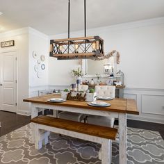 a dining room table with plates and place settings on it, hanging from a chandelier