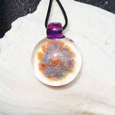 WOW! This is an amazing small one-of-a-kind blown glass pendant. Handmade from borosilicate glass and annealed for strength and durability, this pendant will last forever.  The pendant features a riot of colors trapped within clear glass, capturing the essence of enchantment and wonder. Each piece is expertly crafted, ensuring that no two pendants are exactly alike, making this piece truly unique. The pictured piece is the one you will be holding in your own hand. Elegantly suspended from a 16 i Artistic Glass Round Pendant Necklaces, Artistic Glass Necklace With Round Pendant, Artistic Glass Round Pendant Necklace, Handmade Statement Necklace, Heady Glass, Blown Glass Pendant, Glass Pendant Necklace, Glass Necklace, Necklace Gift