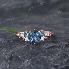 a blue and white diamond ring sitting on top of a rock