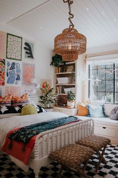 a bed room with a neatly made bed and lots of pictures on the wall behind it