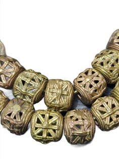 Indulge in the artistry of the Ashanti people with our authentic African brass beads strand. Each strand around 35 African cube shaped beads, meticulously handcrafted in the Ashanti Region of Ghana. These beads are a testament to traditional craftsmanship and are ideal for adding a touch of cultural richness to your jewelry and craft projects. Key Features:1. Genuine African Craftsmanship: Our African brass Adinkra pendants are meticulously handcrafted by skilled artisans from the Ashanti region Unique Faceted Beads For Festival, Artisan Spacer Beads For Jewelry Making, Traditional Gold Beaded Bracelets With Wooden Beads, Bronze Beaded Necklaces With Large Beads For Gift, Bohemian Faceted Beads For Crafting, Large Bronze Round Beads, Gold Artisan Beaded Bracelet With Spacer Beads, Gold Artisan Beaded Bracelets With Spacer Beads, Artisan Gold Beaded Bracelets With Spacer Beads