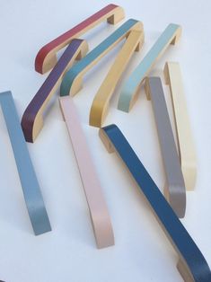 several different colored wooden handles on a white surface