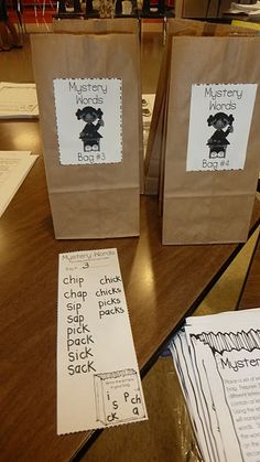 two brown paper bags sitting on top of a wooden table