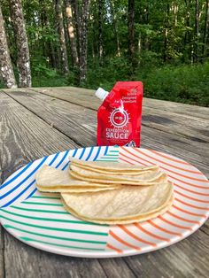 three tortillas on a plate with a bag of salsa